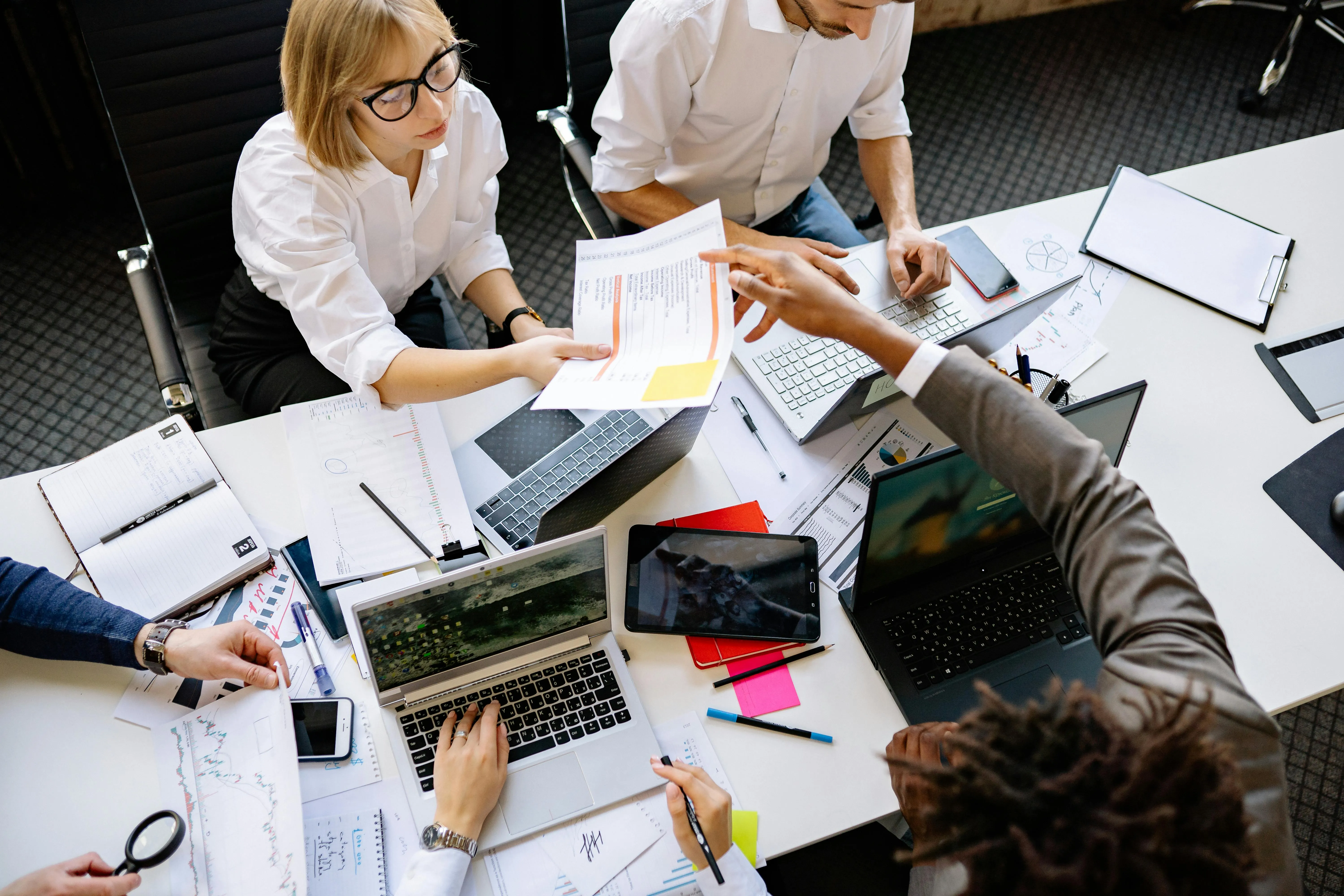 #FotoDescrição: Equipe de profissionais reunida em uma mesa de trabalho, analisando documentos e planejando estratégias de remarketing.